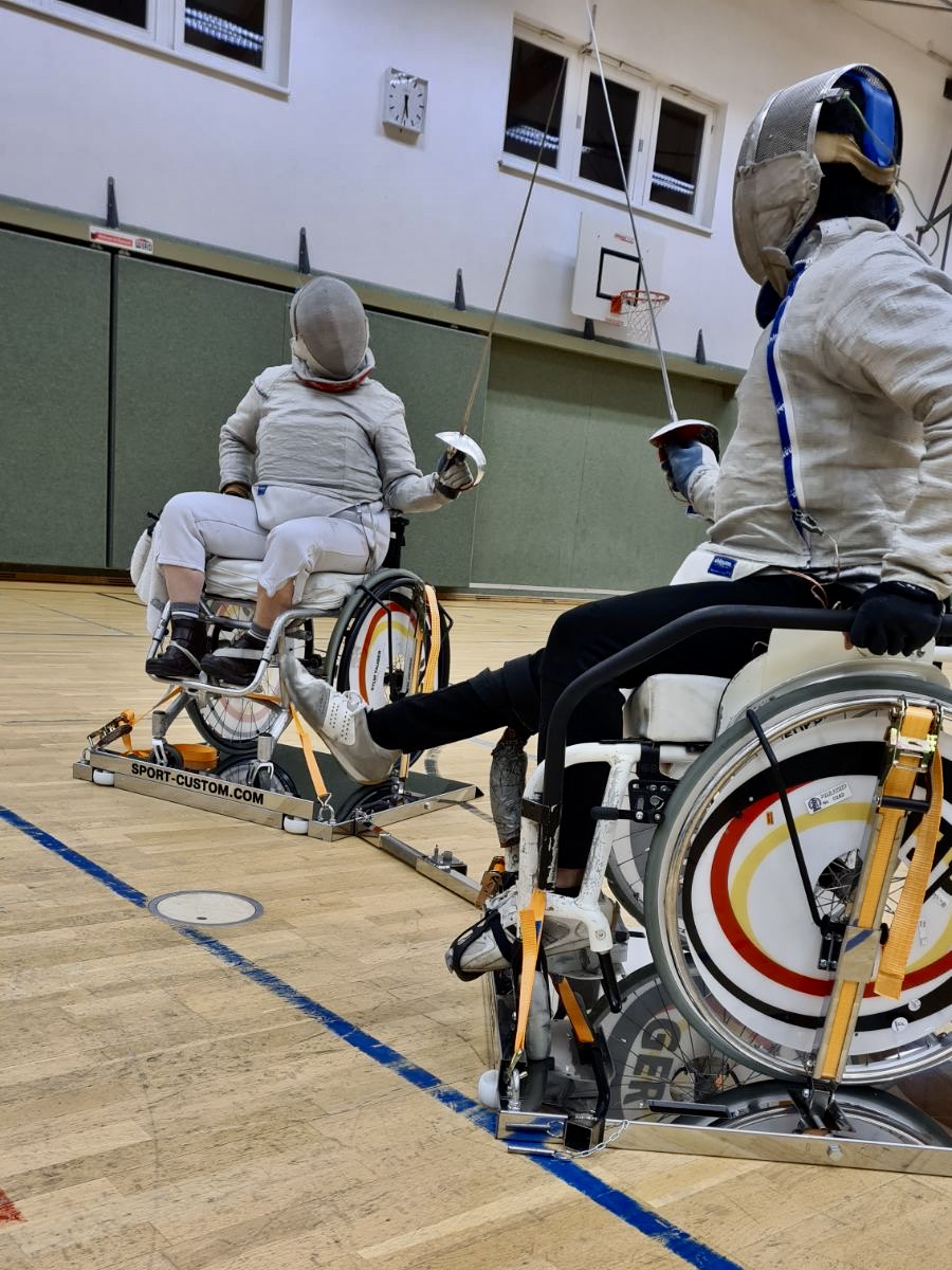 Wheelchair fencing — close action shot, two athletes on frames