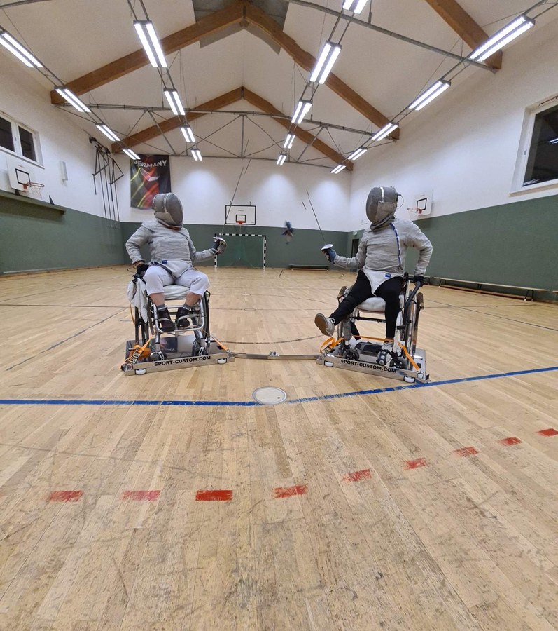 Wheelchair fencing — full court view, both frames connected